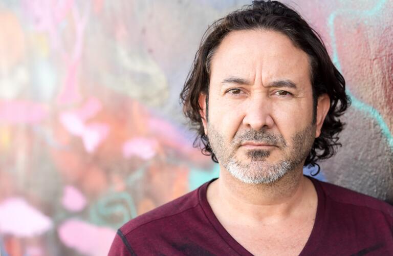 serious portrait of man standing against street art