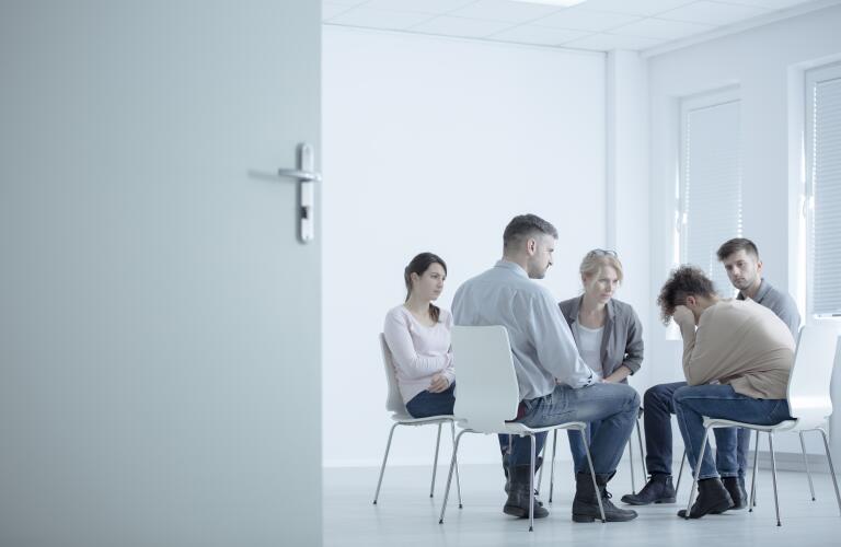 Group of people at group therapy, grief counseling, addiction treatment or substance abuse counseling