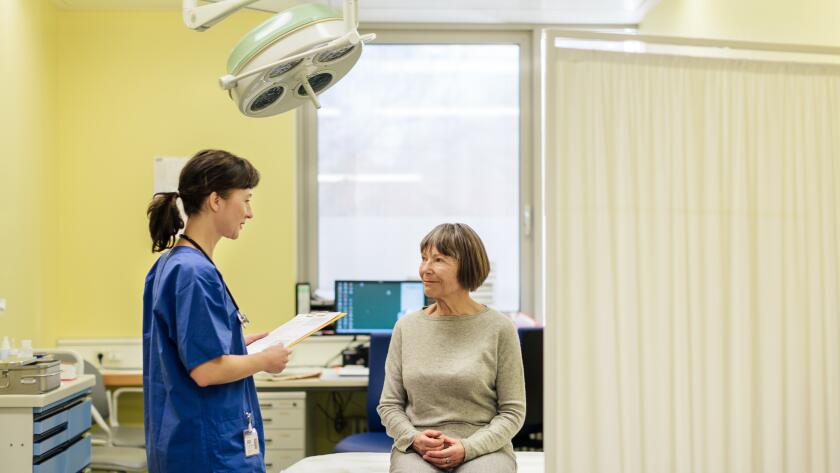 female doctor with female patient in hospital room