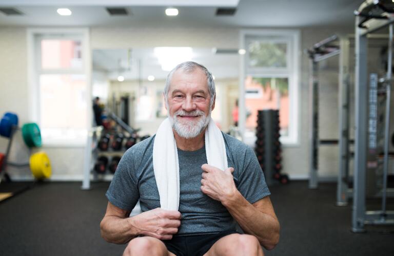 Caucasian senior man in gym smiling during ab exercises