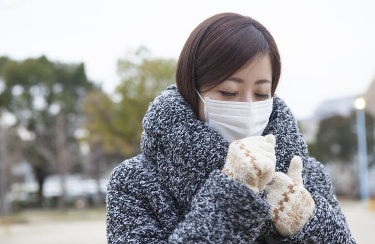 woman walking outside in winter wearing face mask