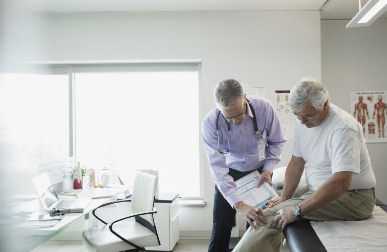 Older man with knee pain with doctor