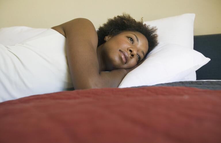 young-woman-laying-in-bed-awake