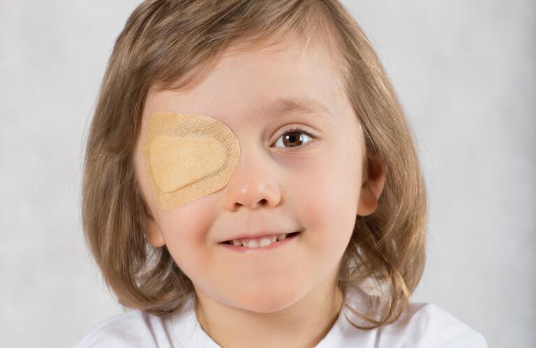 Boy with one eye covered with adhesive patch