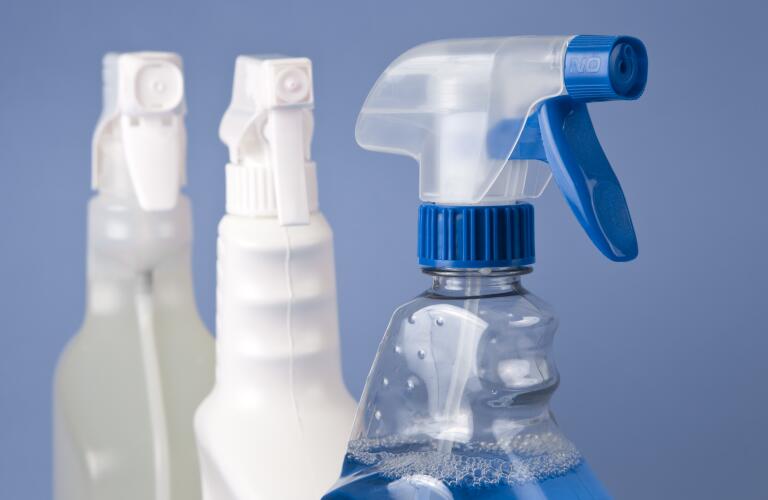 group of spray bottles against blue background