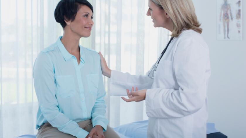 Smiling female doctor talking to patient in office