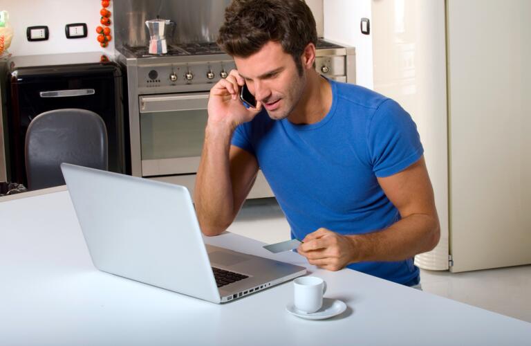 Man in kitchen with laptop