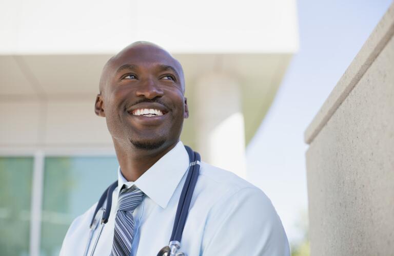 African american doctor standing outside looking up