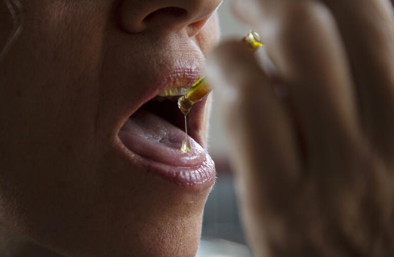 Woman taking cannabis drops