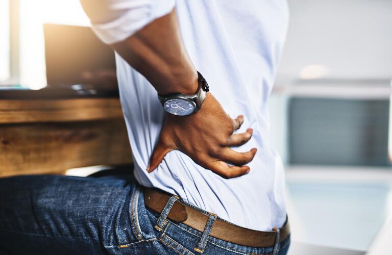 Unseen African American man holding back in pain