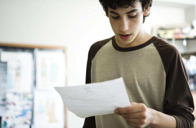 teen-looking-at-sheet-of-paper
