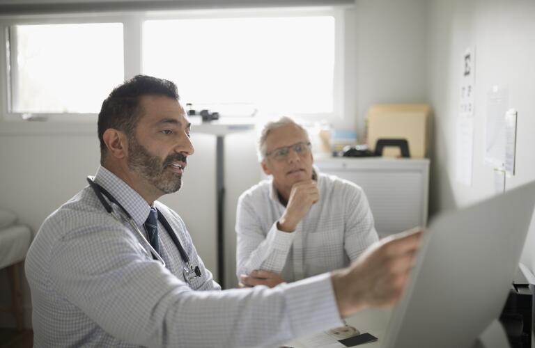 doctor showing patient computer screen at appointment healthcare crm