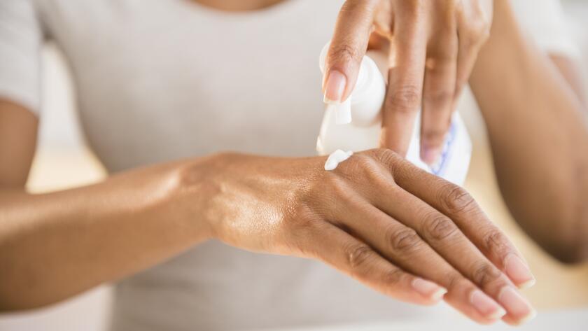woman-putting-moisturizer-on-hand
