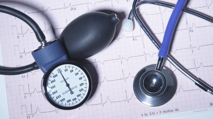 Acoustic stethoscope and blood pressure gauge on an electrocardiogram printout