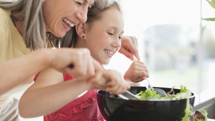 Girl makes salad with grandma