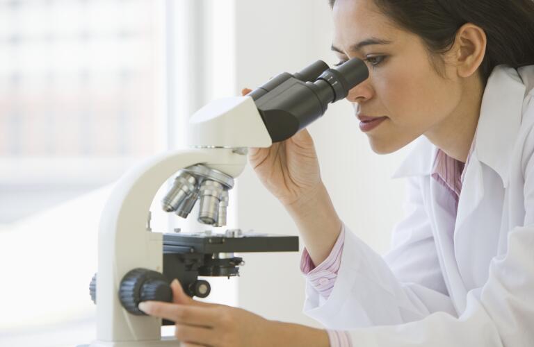Researcher using microscope