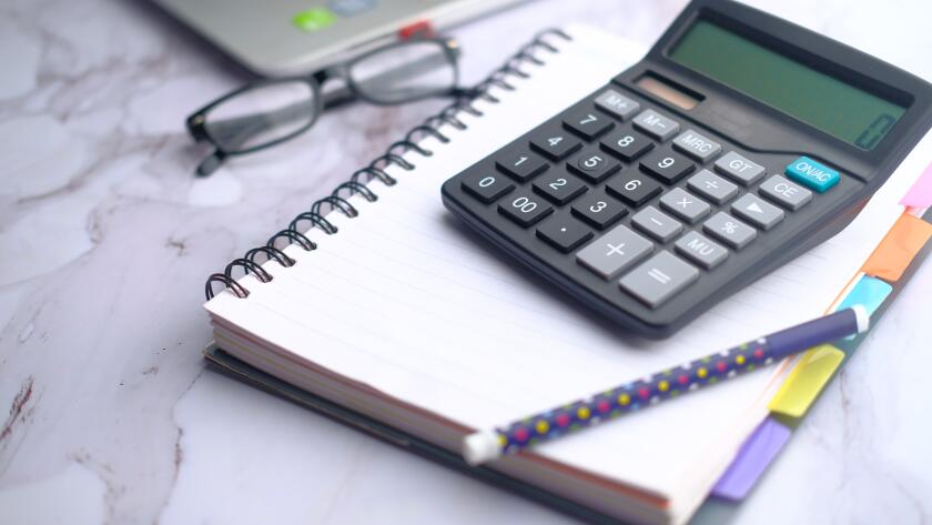 closeup calculator pen notebook eyeglasses and laptop on office table