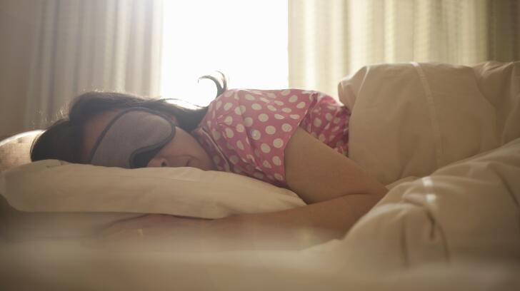 woman-wearing-sleep-mask-on-bed