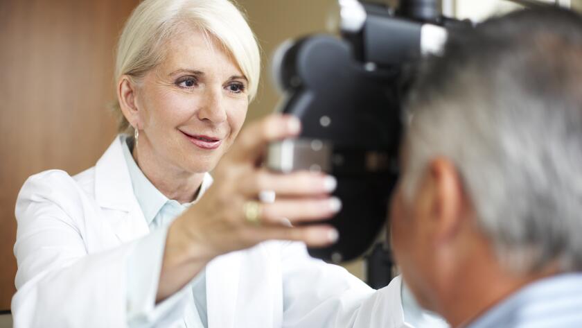 female eye doctor checking patient's vision