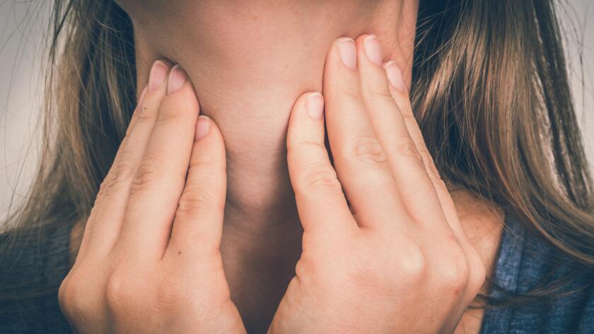 Close-up of Caucasian woman feeling neck with hands