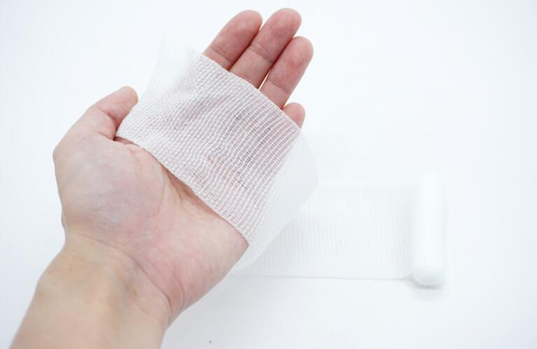 hand holding wound dressing for injury