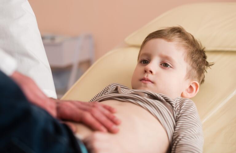 Little boy at medical checkup getting abdomen examined