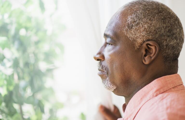 serious-senior-man-looking-out-window