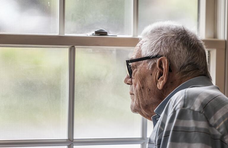 senior-man-staring-out-window