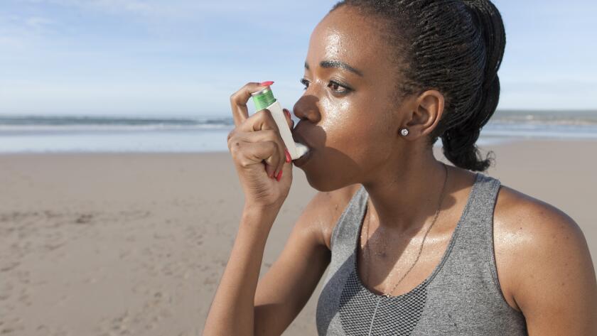woman-on-beach-using-inhaler
