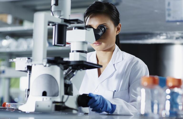 Female Scientist Looking Through Microscope
