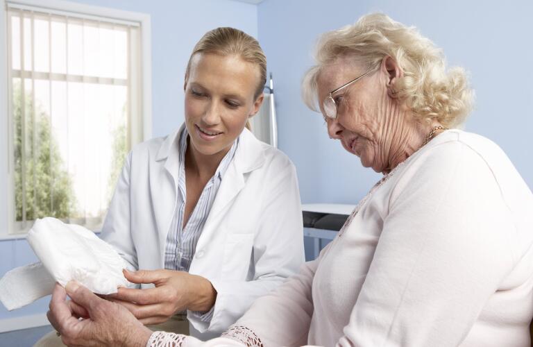 doctor-with-elderly-female-patient-holding-urinary-incontinence-pad