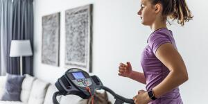 Young woman at home on treadmill in living room
