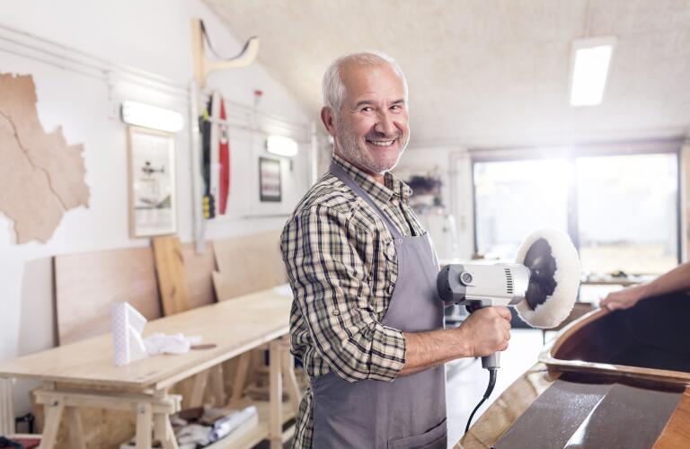 Senior male carpenter using a sander