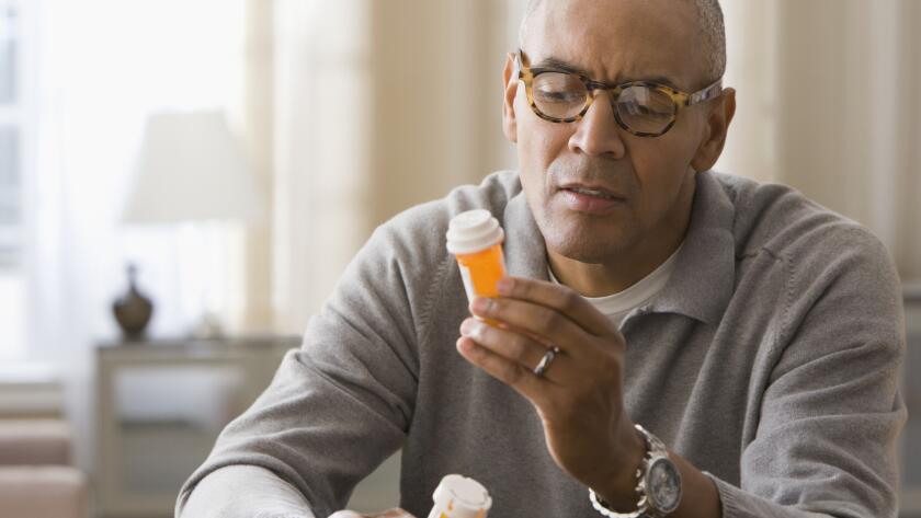 man-holding-two-bottles-of-pills
