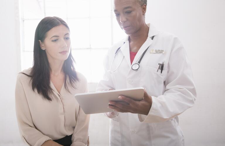 Female doctor using digital tablet in consultation