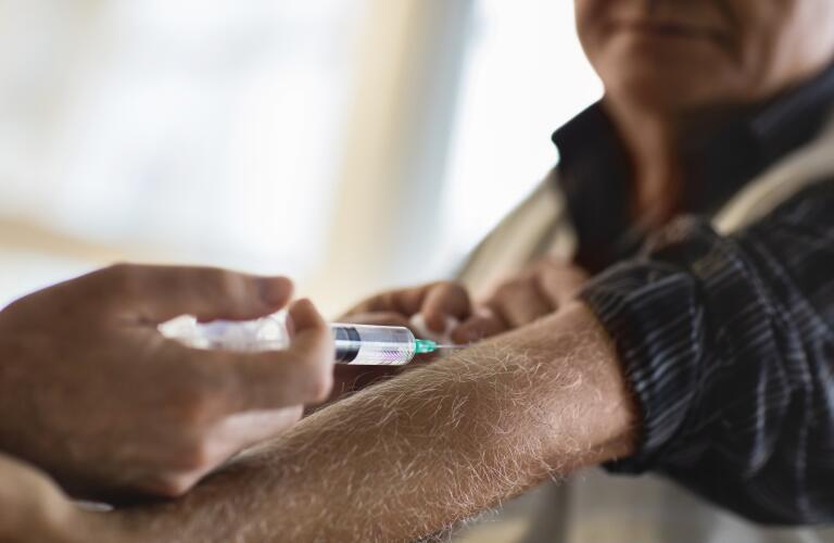 man receiving vaccination in arm from doctor