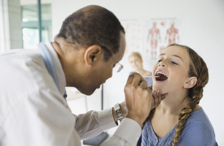 doctor-examining-girl-with-tongue-depressor