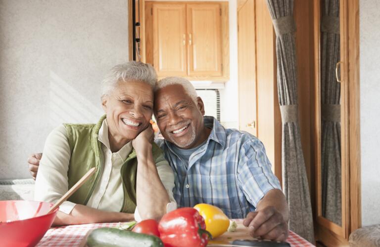 senior couple sitting at dinner table in front of healthy food