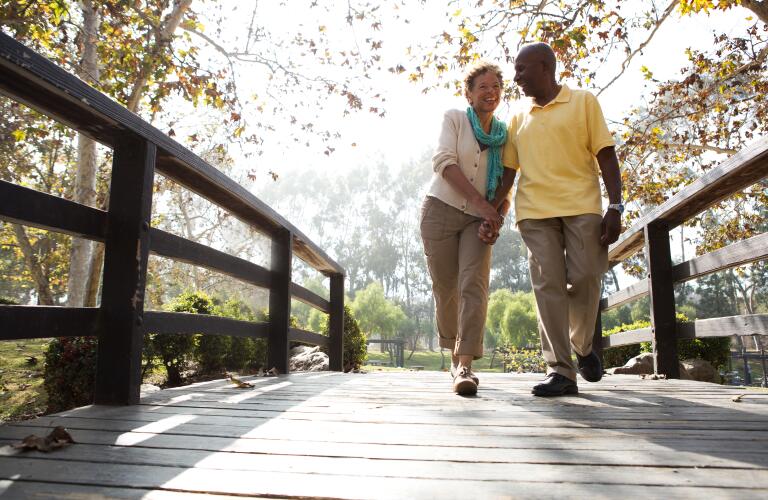 senior couple walking over bridge