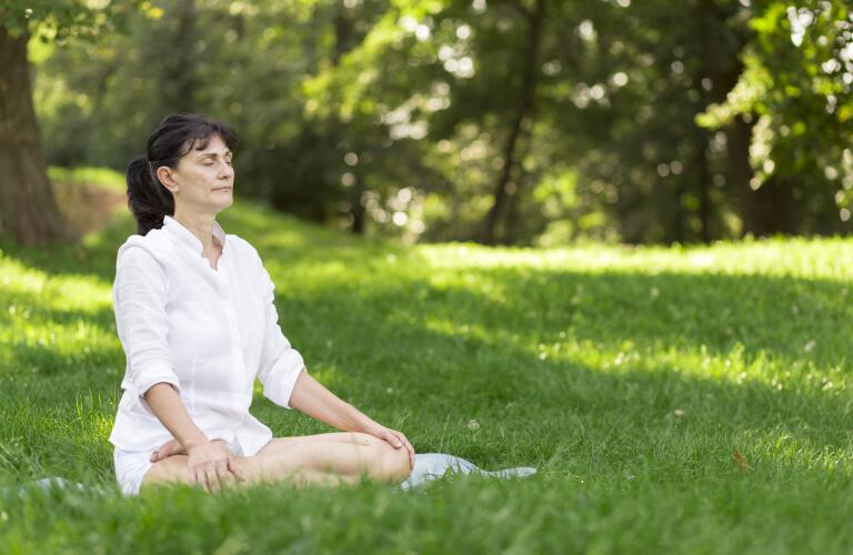 woman meditating in field outside