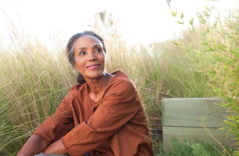 serene woman sitting outside in field