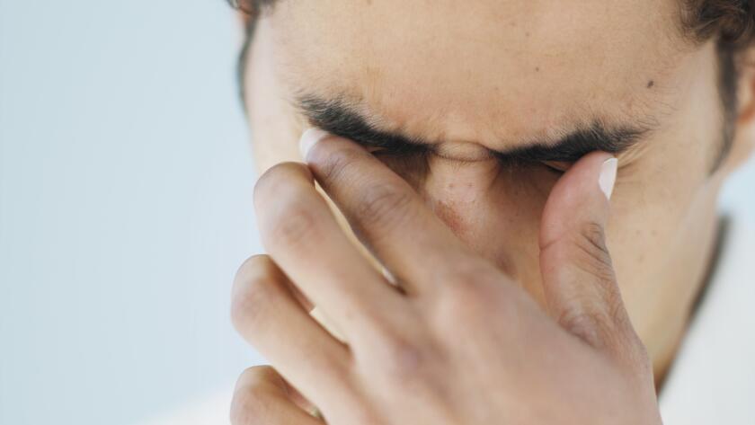 man rubbing eyes