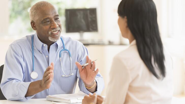 Black doctor and patient talking in office