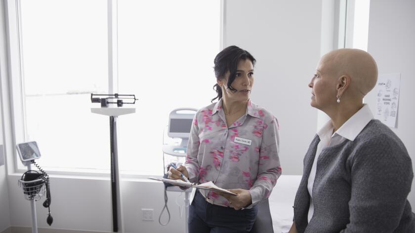 Female cancer patient with doctor in doctor's office