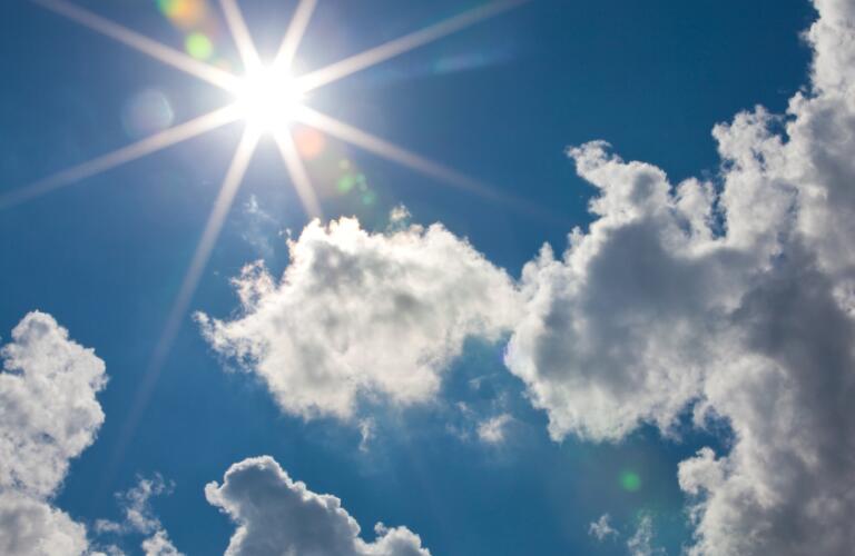 Cumulus clouds with sun flare