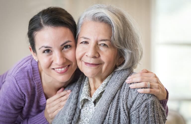 Close up of smiling mother and daughter hugging