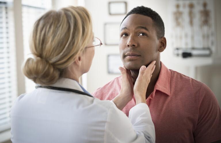 Doctor examining man's neck