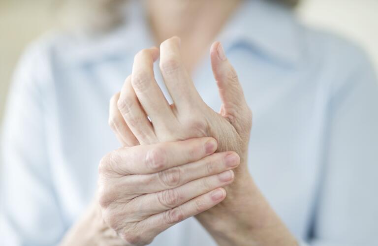 senior woman holding painful hand