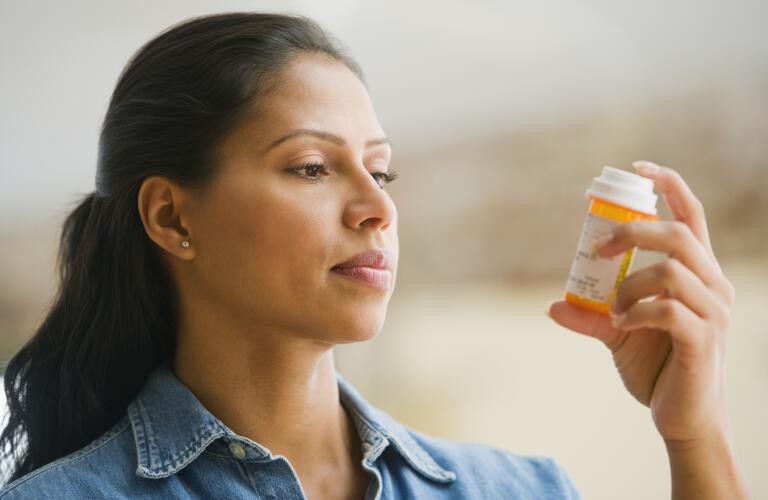Hispanic woman reading medication