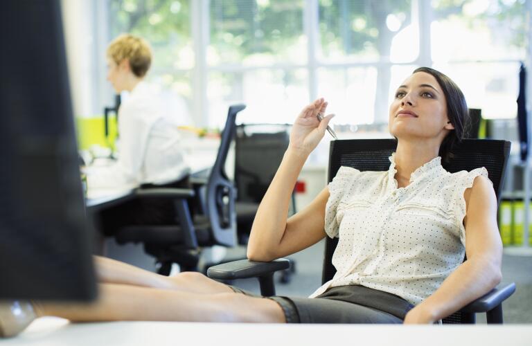 woman daydreaming at office desk